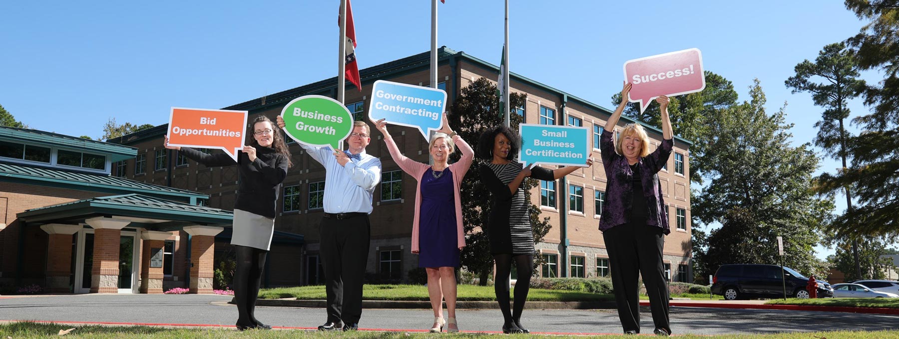 Arkansas PTAC staff holding signs with benefits of choosing PTAC